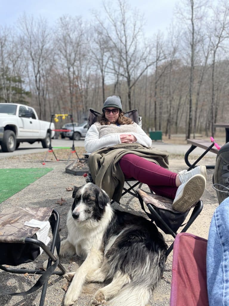 Dog and owner relaxing at campsite