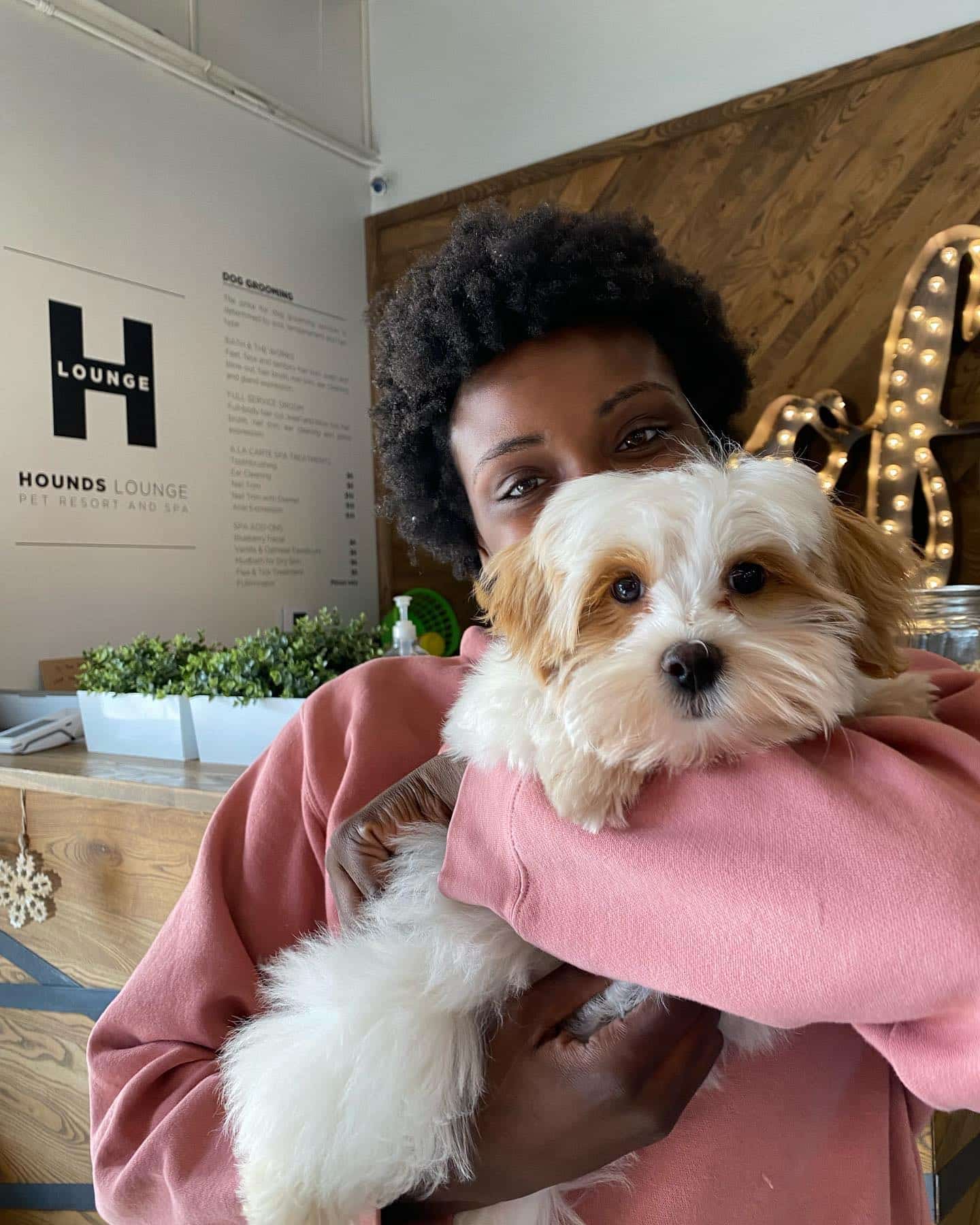 Loving Hounds Lounge staff member holding pup